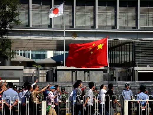 Demonstrators chant slogans and carry a Chinese national flag as they march past riot police outside the main entrance to the Japanese embassy in Beijing September 17, 2012. Chinese police used pepper spray, tear gas and water cannon to break up an anti-Japan protest in southern China on Sunday as demonstrators took to the streets in scores of cities across the country in a long-running row with Japan over a group of disputed islands. REUTERS/David Gray (CHINA - Tags: CIVIL UNREST POLITICS)