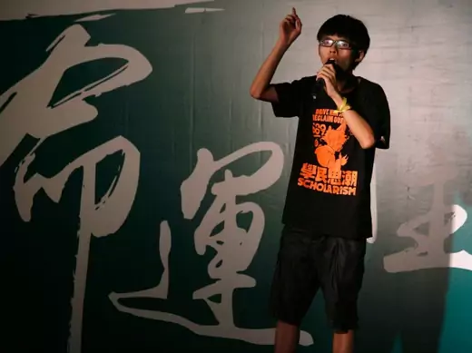 Joshua Wong, a 17-year-old who heads the group leading a pupils' protest, Scholarism, addresses a rally in Hong Kong September 26, 2014.  Hundreds of children joined students demanding greater democracy for Hong Kong on Friday, capping a week-long campaign that has seen a large cut-out depicting the territory's leader as the devil paraded through the city and calls for him to resign. The Chinese characters on the background read "Fate". REUTERS/Bobby Yip (CHINA - Tags: POLITICS EDUCATION CIVIL UNREST)