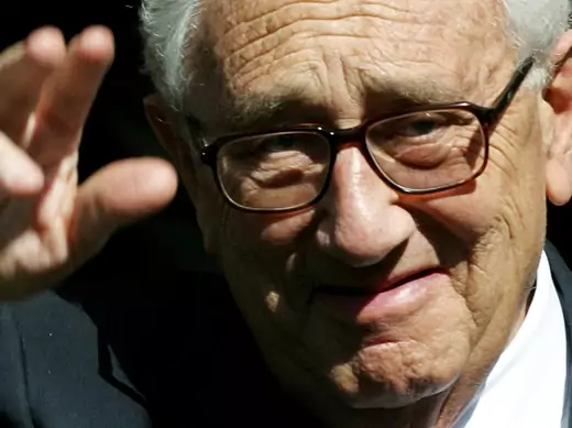 Former U.S. Secretary of State Dr. Henry Kissinger waves to the media as he leaves the Royal Albert Hall in London on April 24, 2002. (Kieran Doherty/Courtesy Reuters)