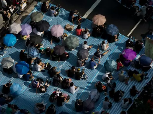Protesters sit under umbrellas at a main street at Mongkok shopping district after thousand of protesters blocked the road in Hong Kong on October 1, 2014. (Tyrone Siu/Courtesy Reuters)