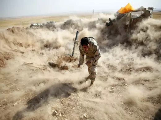 A Kurdish peshmerga fighter launches mortar shells (Jadallah/Courtesy Reuters).