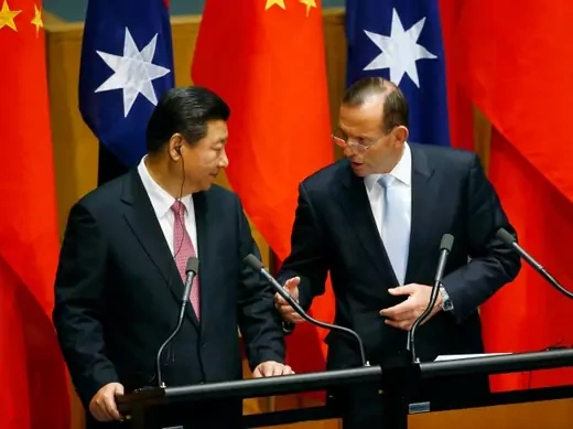 China?s President Xi Jinping (L) listens as Australia's Prime Minister Tony Abbott speaks after a signing ceremony for a free trade deal at Parliament House in Canberra November 17, 2014. China and Australia on Monday signed a declaration of intent on a landmark free trade deal more than a decade in the making, opening up markets worth billions to Australia and loosening restrictions on Chinese investment. Xi is on a three-day official visit to Australia following the G20 leaders summit which was held in B