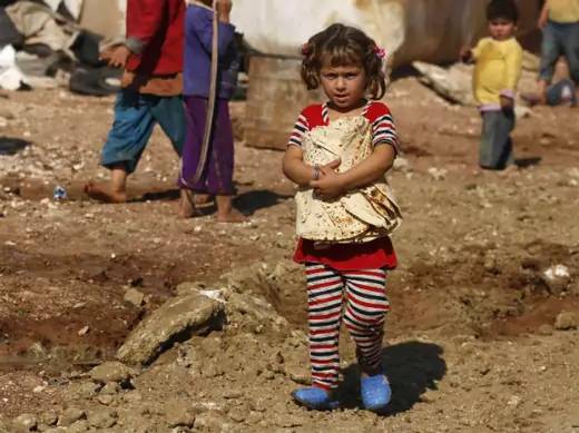 A Syrian girl carries bread in the Bab al-Salam refugee camp in Azaz, near the Syrian-Turkish border, October 27, 2014.