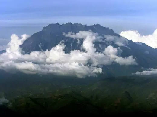 Mount Kinabalu appears through the clouds over Kota Kinabalu, capital of the east Malaysian state of Sabah on Borneo island, in this March 8, 2002 aerial photograph. Known as "aki nabalu" or "home of the spirits of the dead" to the Kadazan Dusun locals, Kinabalu is Southeast Asia's highest mountain, standing at 4,095 metres (13,432 feet). Picture taken March 8. REUTERS/Bazuki Muhammad