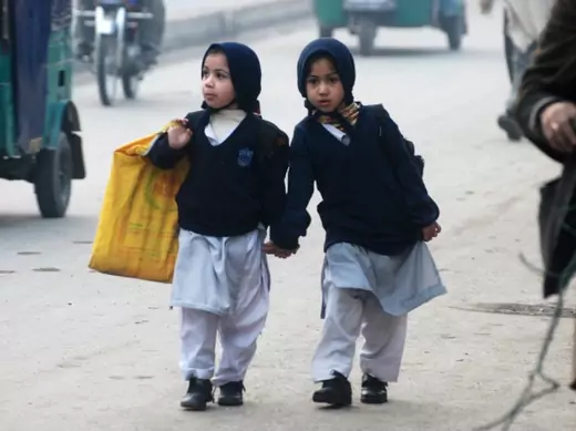 Girls carry their school bags as they walk along a road while heading to their school after it reopened in Peshawar, Pakistan, on January 12, 2015 (Courtesy Reuters/Khuram Parvez). 