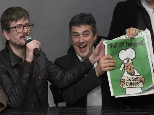 Satirical French magazine Charlie Hebdo columnist Patrick Pelloux (R) and cartoonist Luz (L) show a copy of their next issue titled "Tout est pardonne" ("All is forgiven") showing a caricature of Prophet Mohammad during a news conference at the French newspaper Liberation offices in Paris, January 13, 2015 (Wojazer/Courtesy Reuters).