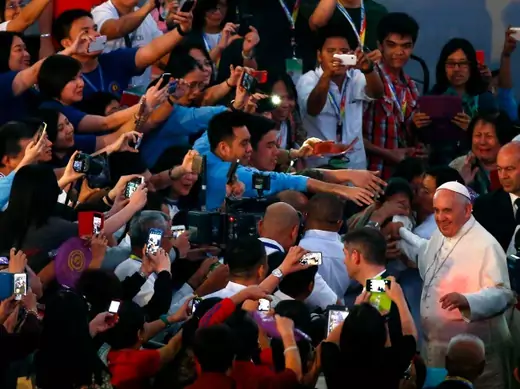 Pope Francis waves to the Catholic faithful as he arrives for a meeting with Filipino families in Manila January 16, 2015. Pope Francis called on the Philippine government on Friday to tackle corruption and hear the cries of the poor suffering from "scandalous social inequalities" in Asia's most Catholic country. The Pope arrived the Philippines on Thursday for a five-day visit, the second and last leg of his week-long Asian tour. REUTERS/ Stefano Rellandini ( PHILIPPINES - Tags: RELIGION POLITICS SOCIETY)