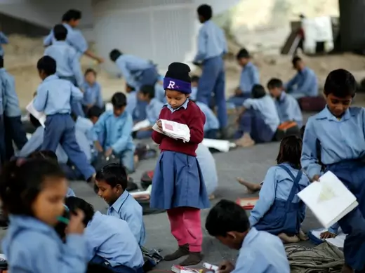 A schoolgirl reads from a textbook at an open-air school in New Delhi, India, November 2014 (Courtesy Reuters/Anindito Mukherjee).