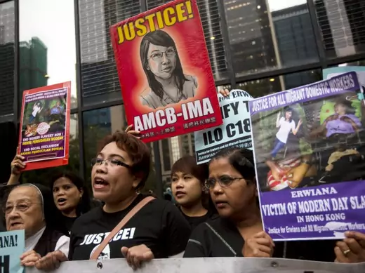 Supporters hold signs of Indonesian domestic helper Erwiana Sulistyaningsih, during a protest calling for better protection of migrant workers, outside the district court in Hong Kong February 27, 2015. Former beautician Law Wan-tung, 44, a mother of two, was found guilty of 18 of 20 charges including grievous bodily harm and violence against Sulistyaningsih and two other maids, also from Indonesia. She is due to be sentenced on Friday. REUTERS/Tyrone Siu (CHINA - Tags: CRIME LAW BUSINESS EMPLOYMENT CIVIL 