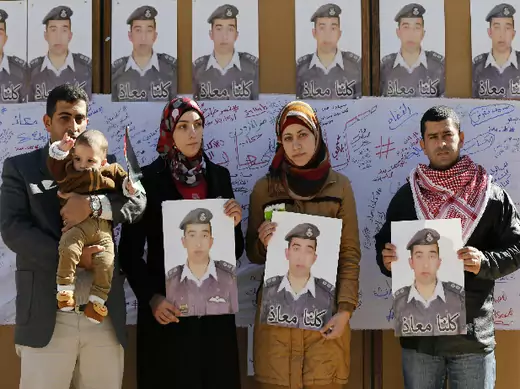 Relatives of Islamic State captive Jordanian pilot Muath al-Kasaesbeh hold pictures of him as they join students during a rally calling for his release, at Jordan University in Amman February 3, 2015 (Hamed/Courtesy Reuters).