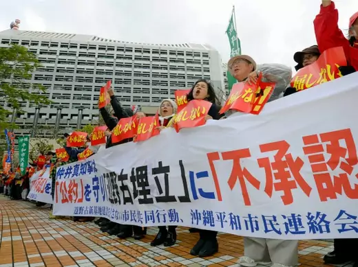 Protesters shout slogans during a rally against the relocation of a U.S. military base, in front of the Okinawa prefectural government office building, in Naha on the Japanese southern islands of Okinawa, in this photo taken by Kyodo December 27, 2013. Okinawa Governor Hirokazu Nakaima approved on Friday landfill work for the relocation of the U.S. military's Futenma air base within his prefecture, going back on his pledge to move the base out of Okinawa, Kyodo news reported. The banner reads, "No recognit