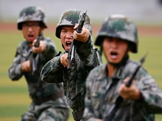 People's Liberation Army (PLA) soldiers shout as they hold guns and practise in a drill during a organized media tour at a PLA engineering school in Beijing, July 22, 2014. REUTERS/Petar Kujundzic (CHINA - Tags: MILITARY TPX IMAGES OF THE DAY)