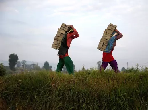 Women carry bricks on their back as they work at a brick factory in Bhaktapur, Nepal, May 2015. (Courtesy Ahmad Masood/Reuters)