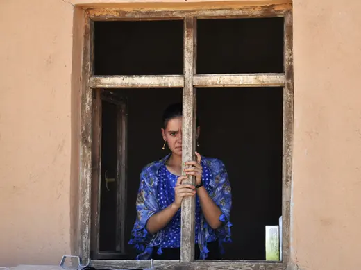 A displaced woman from the minority Yazidi sect, fleeing violence in Iraq, looks out from an abandoned house where she is taking refuge in the southeastern Turkish town of Silopi