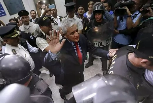 Guatemala's former President Otto Perez Molina gestures while being escorted by police officers after a hearing at the Supreme Court of Justice in Guatemala City, September 3, 2015. Perez resigned his presidency and turned himself in to a court on Thursday to face charges in a corruption scandal that gutted his government and plunged the country into chaos days before a presidential election. Congress, in an emergency session, approved the resignation of Perez, a 64-year-old retired general who quit overni