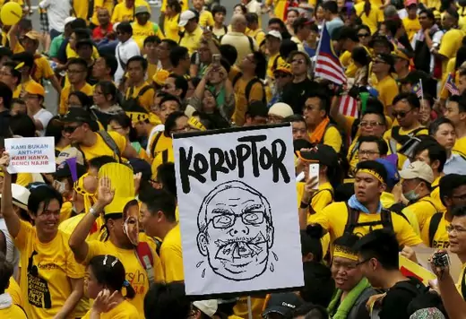 Protesters march at a rally organised by pro-democracy group "Bersih" (Clean) in Malaysia's capital city of Kuala Lumpur, August 29, 2015. Thousands of protesters gathered in Kuala Lumpur on Saturday for a two-day rally to demand the resignation of Prime Minister Najib Razak, bringing to the streets a political crisis over a multi-million-dollar payment made to an account under his name. The placards read, "Corruptor" and "We are not against prime minister, we just hate Najib" (Olivia Harris/Reuters).
