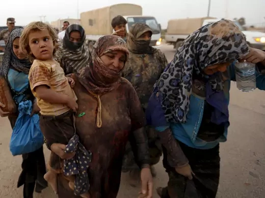 Syrian refugees covered with dust arrive at the Trabeel border