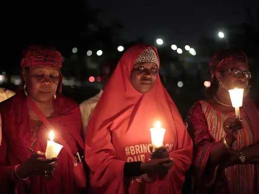 Bring Back Our Girls (BBOG) campaigners raise up candles during a candle light gathering marking the 500th day since the abduction of girls in Chibok, along a road in Abuja