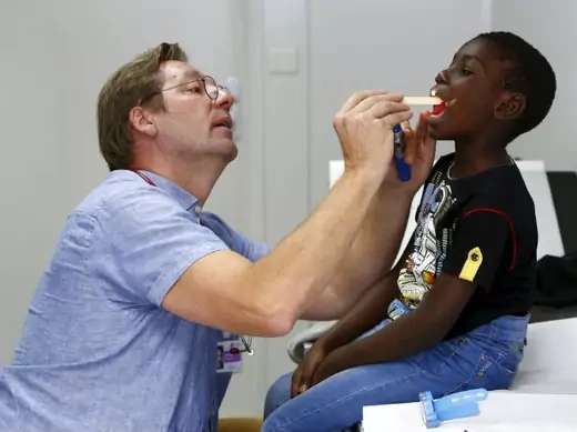 A six-year-old migrant from the Congo receives a medical check-up from a doctor at a refugee camp in Munich, Germany, on October 6, 2015.
