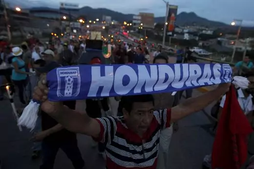 A demonstrator holds a scarf during a march to demand for the resignation of Honduran President Juan Orlando Hernandez in Tegucigalpa August 14, 2015. Thousands of protesters have been continuing demonstrations in Tegucigalpa, calling for the resignation of Hernandez over a $200 million corruption scandal at the Honduran Institute of Social Security (Jorge Cabrera/Reuters).