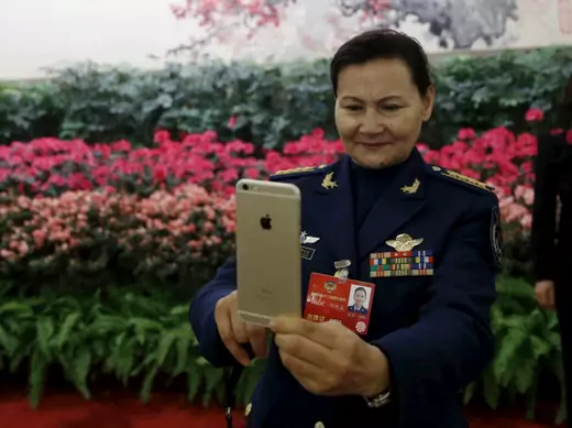 A military delegate takes pictures with her iPhone ahead of the opening session of the Chinese People's Political Consultative Conference (CPPCC) at the Great Hall of the People in Beijing, China, March 3, 2016. (Kim Kyung-hoon/Reuters)