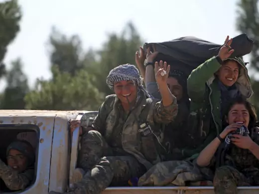 Democratic Forces of Syria women fighters gesture while riding a pick-up truck near the town of al-Shadadi in the Hasaka countryside of Syria on February 18, 2016.