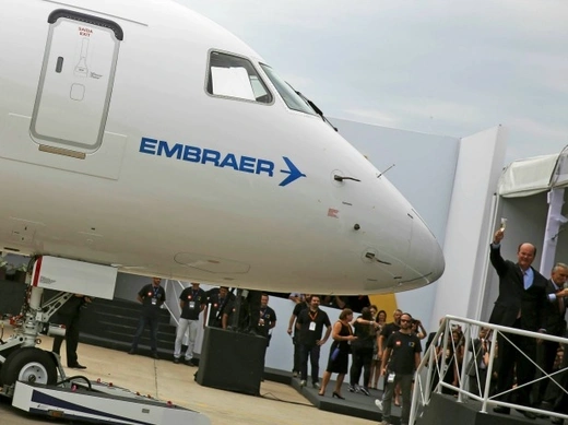 Brazilian aircraft maker Embraer's CEO Frederico Curado (R) salutes workers next to an new Embraer E190-E2 during its unveil in Sao Jose dos Campos, Brazil, February 25, 2016. Brazilian planemaker Embraer SA is in early talks with Iran, with a focus on commercial aviation, following the end of international sanctions, Chief Executive Curado told journalists on Thursday (Reuters/Nacho Doce).