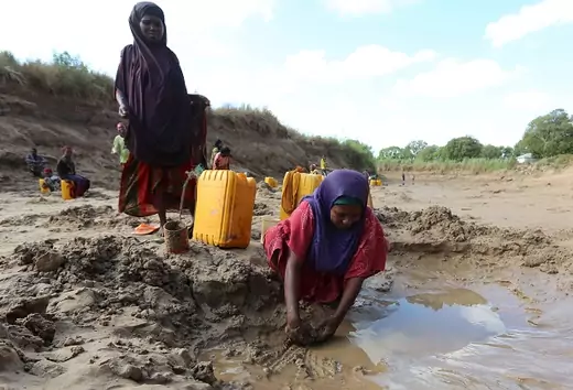 People collect water from shallow wells dug along the Shabelle River bed, which is dry due to drought in Somalia's Shabelle region