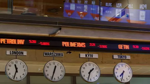 Stock exchange figures are displayed above clocks with time from around the world at Warsaw Stock Exchange.