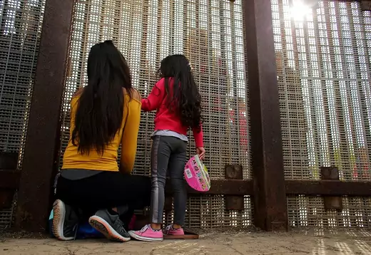 Families separated by the two countries chat along the U.S.-Mexico border fence at Border Field State Park, California