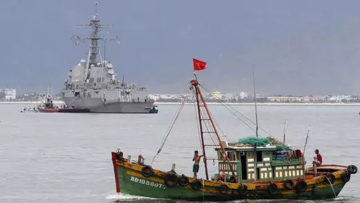 A Vietnamese fishing boat goes past the USS Chung-Hoon at a port in Danang city, July 15, 2011.