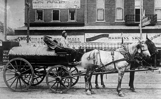 A horse-drawn truck employed by Standard Oil in 1902 delivers gasoline for the first automobiles and stationary engine use. AP