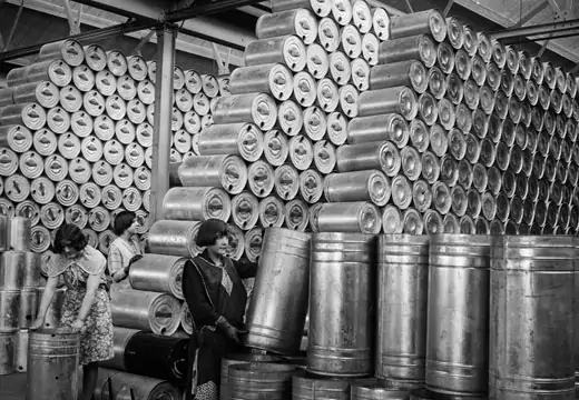 Workers at a factory stacking drums of oil in a warehouse, February 1930. (Getty)