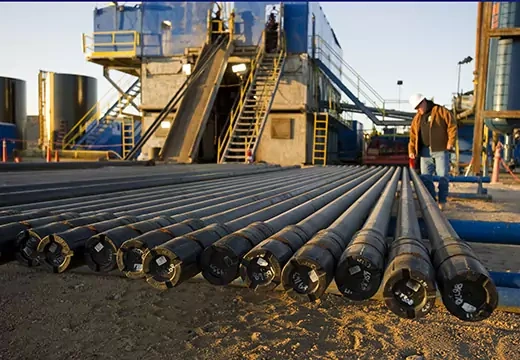 An oil field worker inspects pipe extensions used in oil drilling operations. Rich LaSalle/Getty