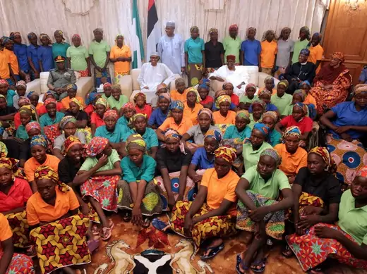 President Muhammadu Buhari sits with eighty-two freed Chibok girls.