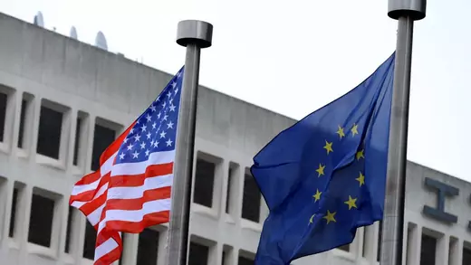 The national flag of the United States flies with the European Union flag in Brussels, Belgium.