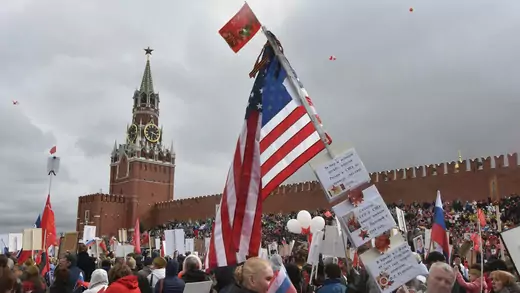 People carry portraits of relatives who fought in World War II and the U.S. flag to mark the Allied victory in World War II, with the Kremlin in the background on May 9, 2017 in Moscow, Russia. 