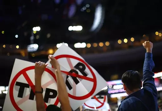 Delegates protesting against the Trans Pacific Partnership (TPP) trade agreement hold up signs. (Carlos Barria/Reuters)
