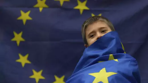 A demonstrator wears an EU flag.