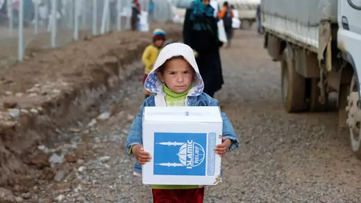 A displaced Iraqi child who fled the Islamic State received humanitarian aid supplies at Al Khazer camp, Iraq.