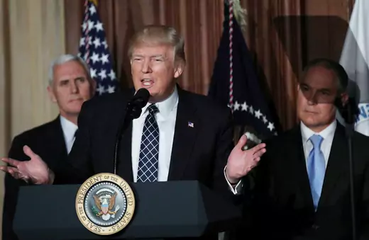 President Donald Trump speaks between Vice President Mike Pence and EPA Administrator Scott Pruitt prior to signing an executive order on "energy independence," eliminating Obama-era climate change regulations, during an event at the EPA