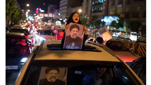 a girl holds a poster of Rouhani