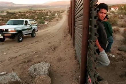 Men wait on the Mexican side of the border to attempt an illegal crossing. Susan Sterner/AP