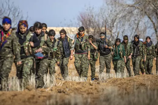 Female fighters of the Kurdish People's Protection Units (YPG) carry their weapons as they walk in the western countryside of Ras al-Ain January 25, 2015. REUTERS/Rodi 