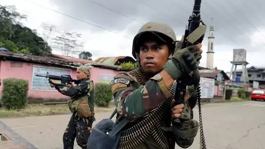 Philippine government troops take cover in Marawi City.