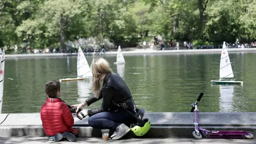 A woman and a child look at miniature sailboats on Mother's Day in Central Park, New York City, U.S., May 14, 2017. REUTERS/Joe Penney