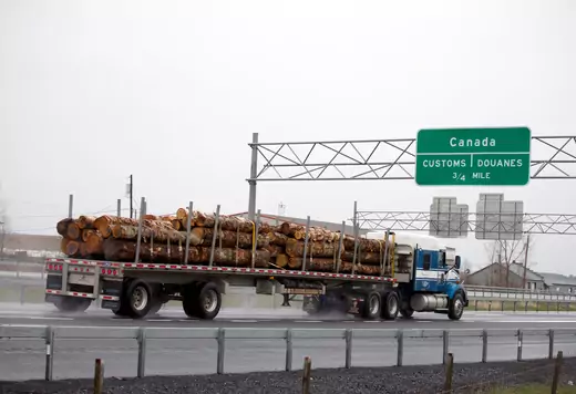 A truck carrying logs heads toward the Canada border. Reuters.