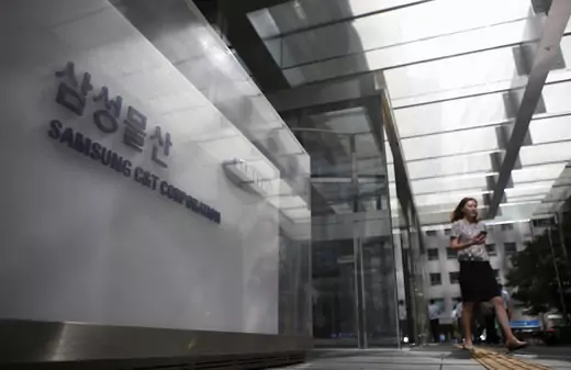 An employee walks past a logo of Samsung C&T Corp at the company's headquarters in Seoul, South Korea, July 16, 2015.