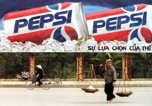 A woman crosses in front of a Pepsi billboard in Hanoi a year after the trade embargo was lifted, February, 1995.