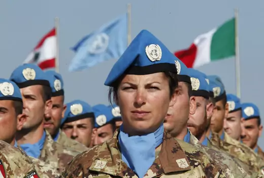 A female UN Peacekeeper stands among her fellow troops as honor guard